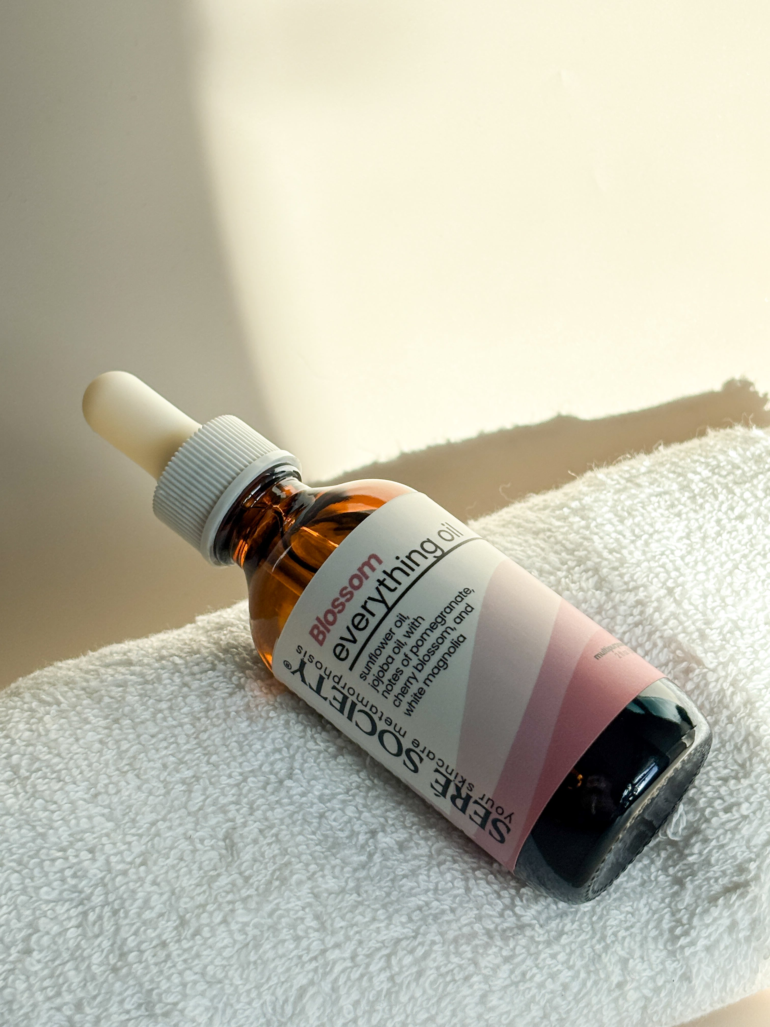 Blossom Everything Oil sitting on top of a towel