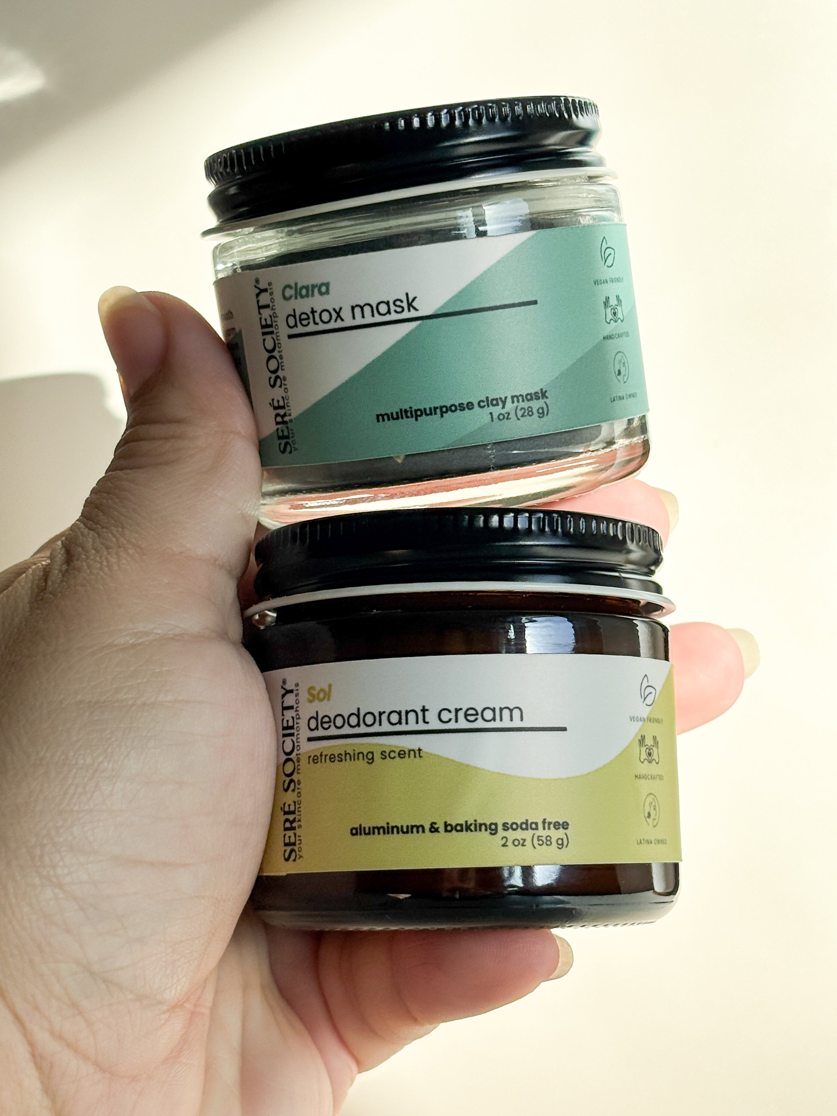 hand holding the Clara detox mask and sol deodorant cream bundle